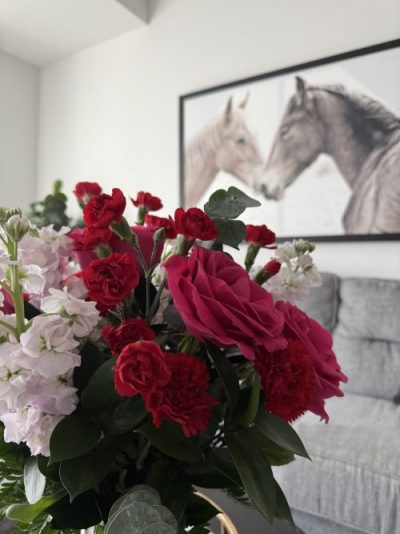 living room with flower bouquet and two horses in photo frame on wall